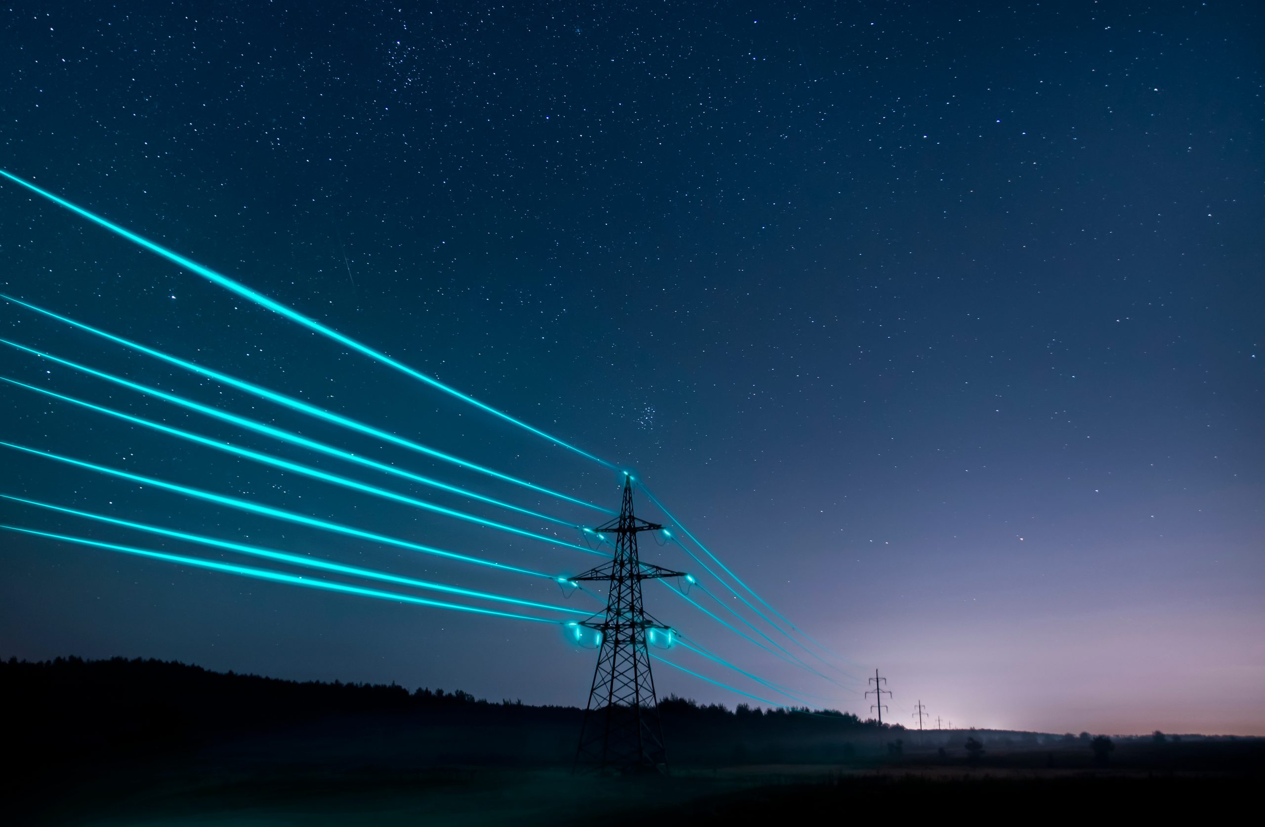 Electricity,Transmission,Towers,With,Glowing,Wires,Against,The,Starry,Sky.